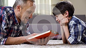 Dad reading son exciting fantasy book, imagination and creativity, leisure time