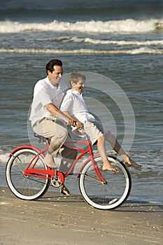 Dad riding bike with son