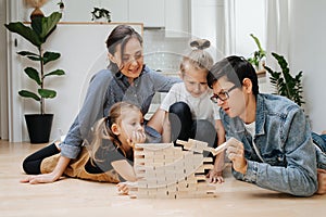 Dad ruining jenga wall, family playing on the floor, pulling tiles