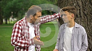 Dad scolding his son for bad behavior, education process, fathers and children