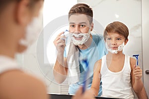 Dad shaving and son imitating him