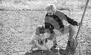 Dad with shovel and boy digging soil. Where food comes from. Teaching son growing plants. Planting plants. Works in