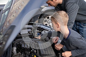 Dad shows his little happy son how the car works