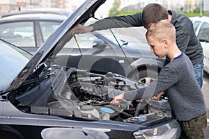 Dad shows his little happy son how the car works