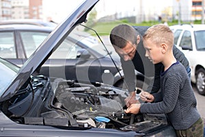 Dad shows his little happy son how the car works