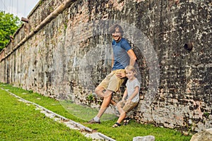 Dad and son on background of Fort Cornwallis in Georgetown, Pena