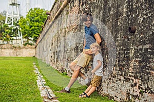 Dad and son on background of Fort Cornwallis in Georgetown, Pena