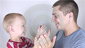 Dad and son clap their hands. Fun game, father taking care of his son, concept of happy boyhood and fatherly upbringing of a boy.