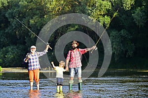 Dad and son fishing at lake. Family fishermen fishing with spinning reel. Grandfather, father and boy fishing together.