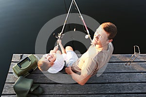 Dad and son fishing together at lake