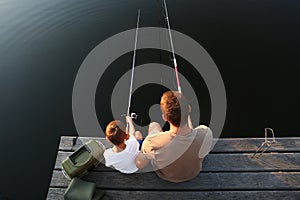 Dad and son fishing together at lake