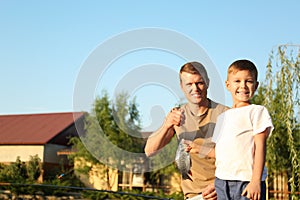 Dad and son fishing together on sunny day