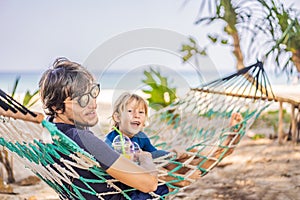 Dad and son having fun in a hammock with a drinks