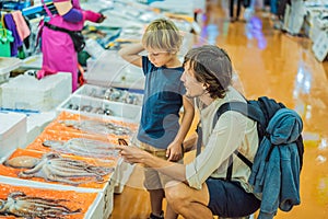 Dad and son in the Korean market. Raw seafood at Noryangjin Fisheries Wholesale Market in Seoul, South Korea. Traveling