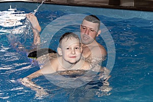 A Dad and son learn to swim in the pool