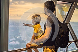 Dad and son are looking at Kuala lumpur cityscape. Panoramic view of Kuala Lumpur city skyline evening at sunset