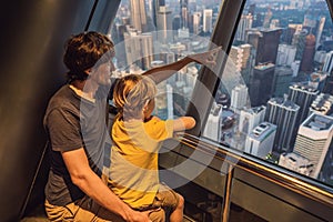 Dad and son are looking at Kuala lumpur cityscape. Panoramic view of Kuala Lumpur city skyline evening at sunset