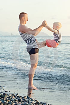 Dad and son are playing on the beach. Fun pastime