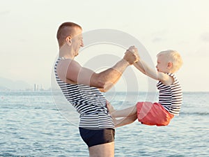 Dad and son are playing on the beach. Fun pastime