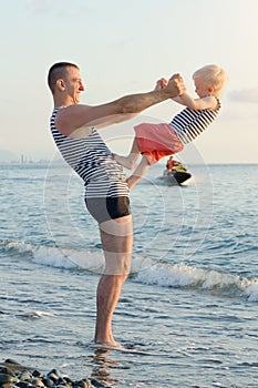 Dad and son are playing on the beach. Fun pastime