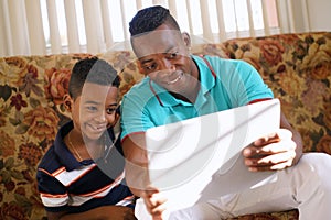 Dad And Son Playing Game With Laptop Pc At Home