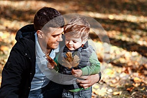 Dad and son playing outside in autumn in the park