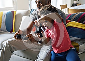 Dad and son playing game at living room together