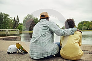 Dad and son resting near the river outdoors