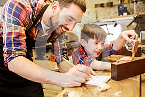 Dad and son with ruler measuring plank at workshop