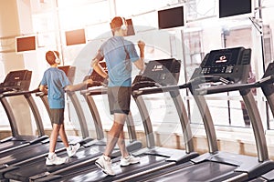 Dad and son in the same clothes in gym. Father and son lead a healthy lifestyle.