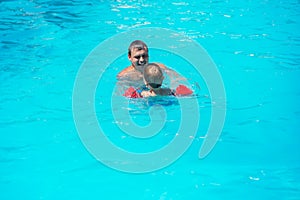 Dad and son swimming together in the pool