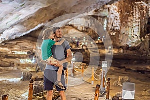 Dad and son tourists in Hang Sung Sot Grotto Cave of Surprises, Halong Bay, Vietnam. Traveling with children concept