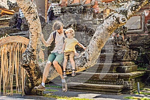 Dad and son travelers in the background of Pura Taman Kemuda Saraswati Temple in Ubud, Bali island, Indonesia BANNER