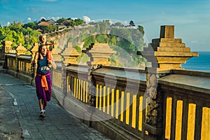 Dad and son travelers in Pura Luhur Uluwatu temple, Bali, Indonesia. Amazing landscape - cliff with blue sky and sea. Traveling wi