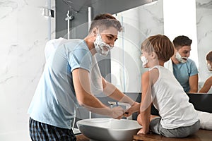 Dad and son washing razors