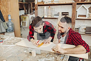 Dad and son in the workshop playing designing a model of a wooden plane