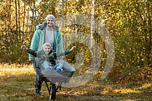 Dad spends time with his son, a happy little boy pushed by a dad. Active outdoor games for children in the fall