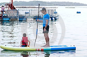Dad and stand-up paddle board together.