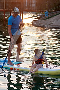 Dad and stand-up paddle board together.