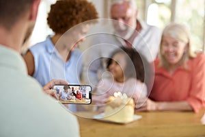 Dad Takes Photo As Multi-Generation Family Celebrate Granddaughter\'s Birthday At Home With Cake