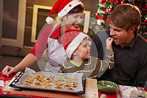 Dad tasting christmas cake with family