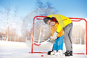 Dad teach little boy son to play ice hockey