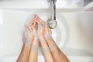 Dad teaches little daughter thorough washing hands