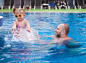 Dad teaches a little daughter to swim