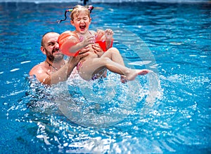 Dad teaches a little daughter to swim