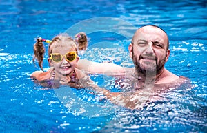 Dad teaches a little daughter to swim