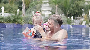 Dad teaches to swim little daughter.