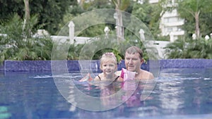 Dad teaches to swim little daughter