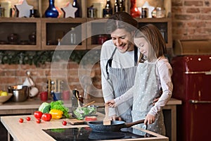 Dad teaching his cute daughter how to cook food on pan