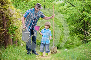 Dad teaching little son care plants. Little helper in garden. Make planet greener. Growing plants. Take care of plants
